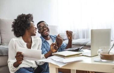 Happy couple with laptop spending time together at home.